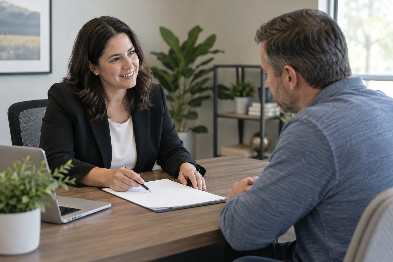 An insurance advisor reviewing blank paperwork with a customer in an office