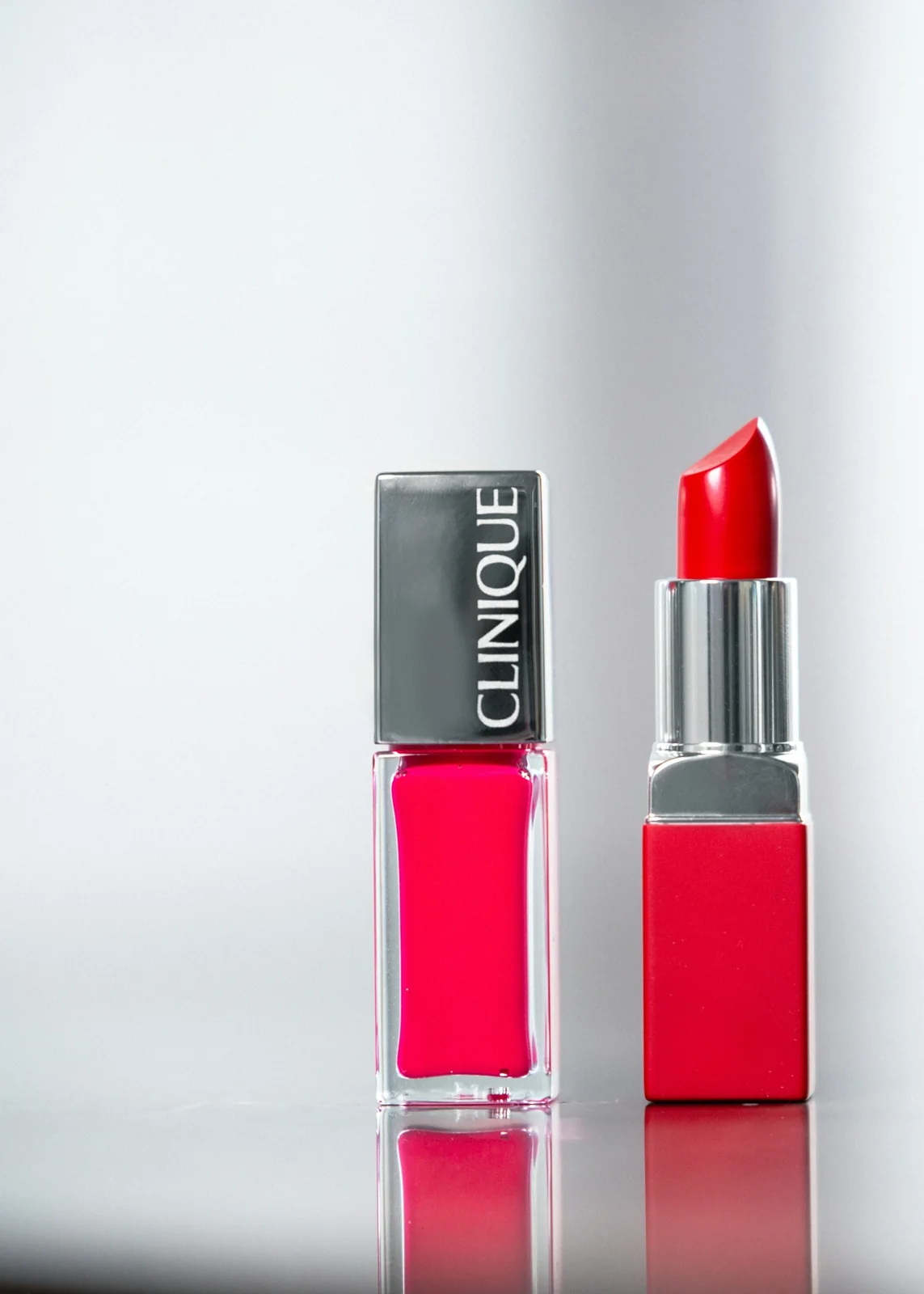 Red lipstick beside pink nail polish